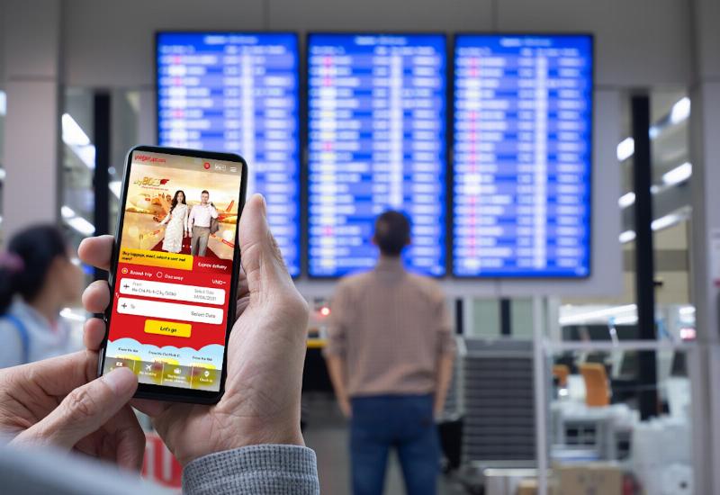 Bàn tay đang cầm điện thoại với giao diện gọi tổng đài Vietjet, bên cạnh là vé máy bay và lịch, thể hiện hành động gọi tổng đài để đổi vé