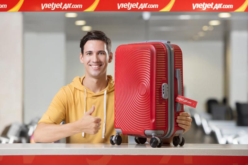 Hình ảnh minh họa một người đang cân hành lý ký gửi tại nhà trước khi đi máy bay Vietjet để kiểm tra trọng lượng