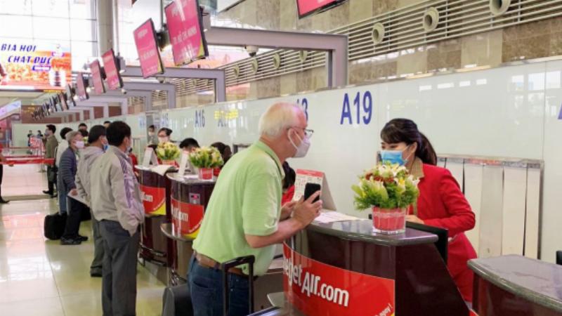 Hình ảnh người dùng đang đặt vé máy bay Tết trên máy tính hoặc điện thoại, thể hiện việc săn vé sớm cho dịp cao điểm
